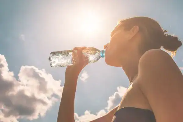 Hydration: The Secret Ingredient for a Toned Stomach and Enhanced Fitness 3 Image of woman drinking water to hydrate East Grinstead after run.